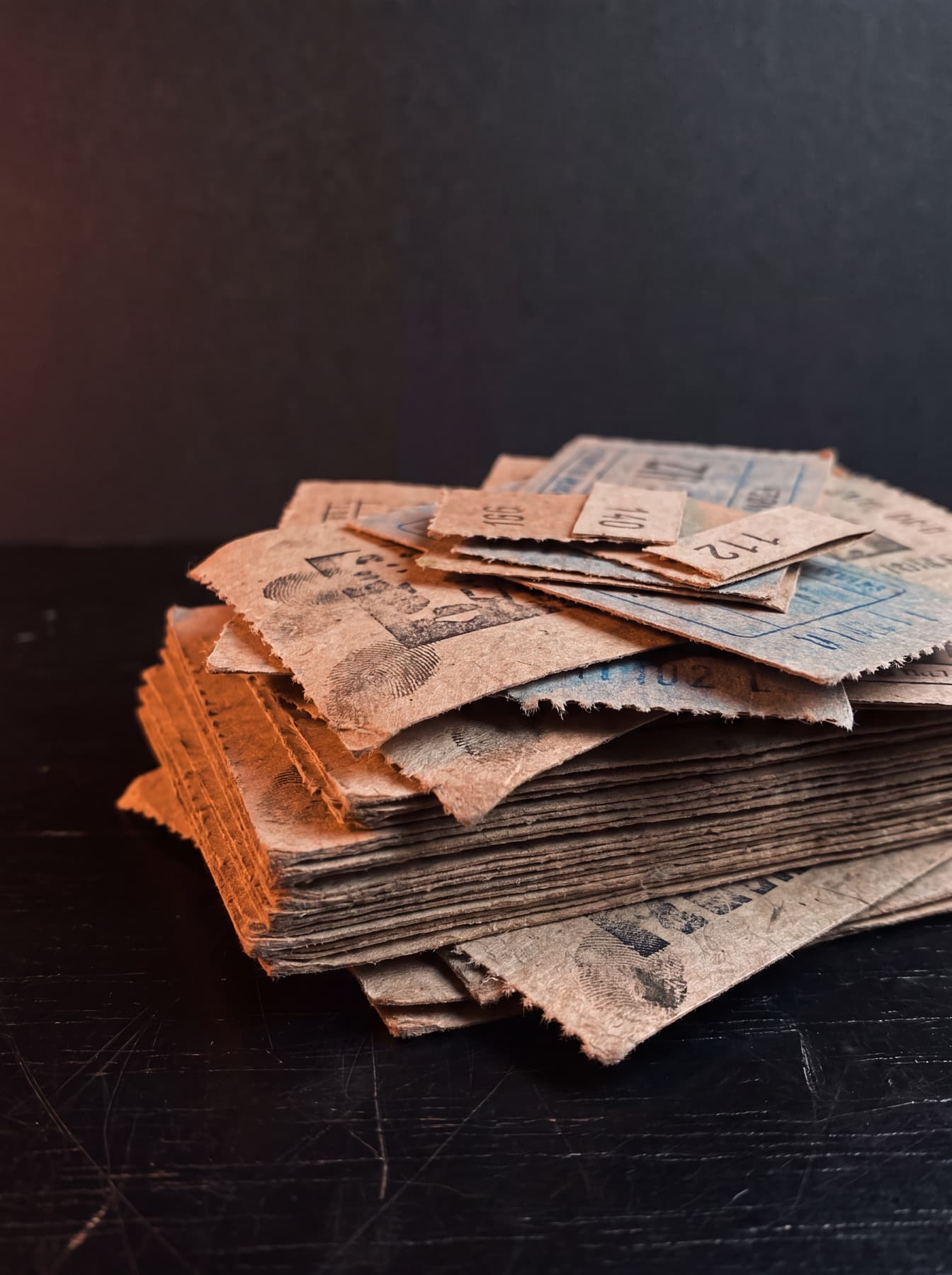 Pilha de bilhetes de rifa sobre uma mesa escura